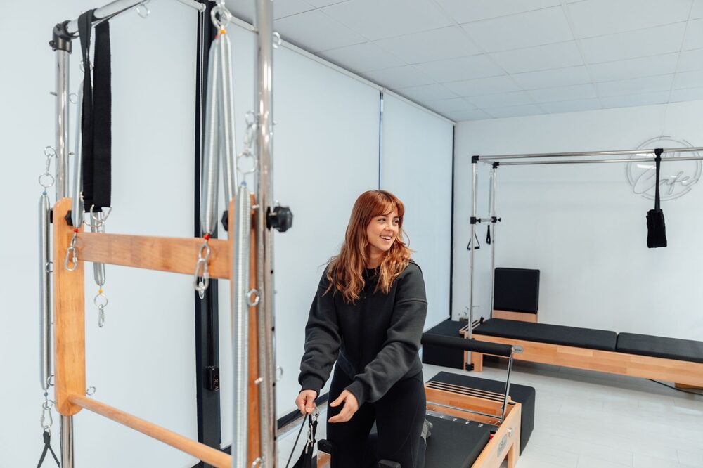 Instructor guiding a client through a precise mat Pilates movement