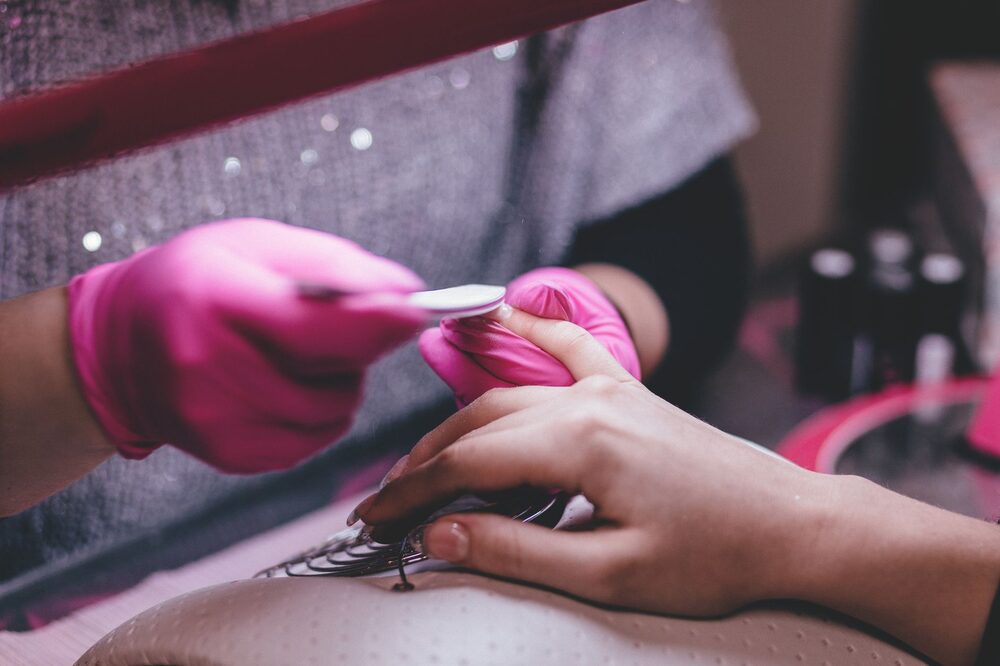 Nail technician applying gel polish at an Edmonton beauty salon station
