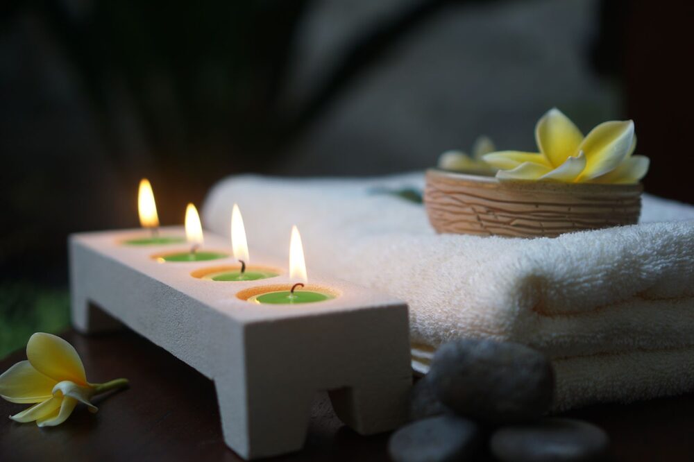Spa wellness products and rolled towels arranged on a calm neutral surface